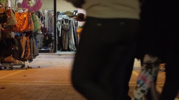 Rue de nuit avec des gens passant par le magasin de vêtements — Video