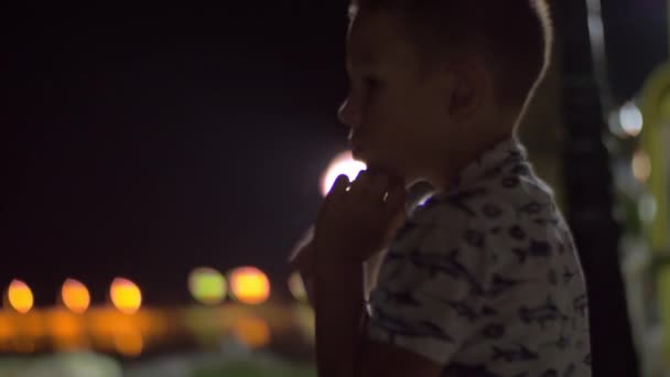 Niño en el balcón por la noche — Vídeos de Stock