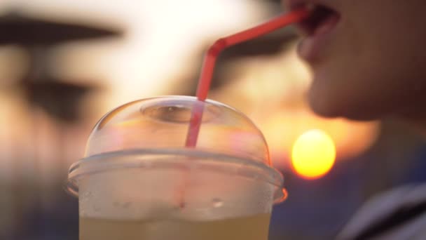 Vrouw iced drankje buiten bij zonsondergang — Stockvideo