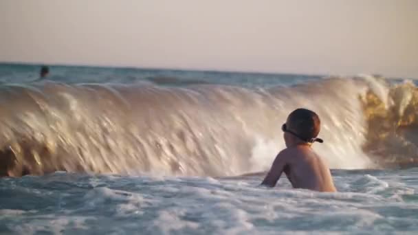 Havet våg mot barnet och täcker honom med spalshes — Stockvideo