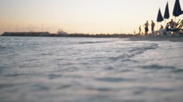 Tengeri hullámok mosás üdülőhely a part, naplementekor — Stock videók