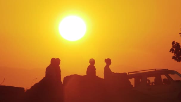 Gente caminando al aire libre contra el atardecer dorado — Vídeo de stock