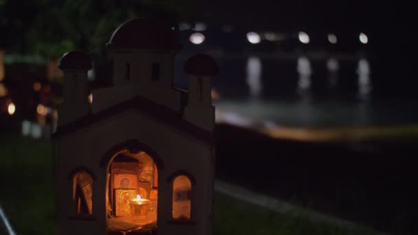 Miniatura de la iglesia ortodoxa griega en frente al mar por la noche — Vídeos de Stock