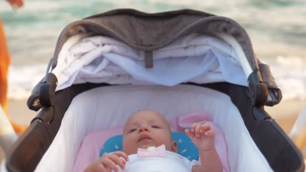 Menina em carrinho de bebé à beira-mar — Vídeo de Stock