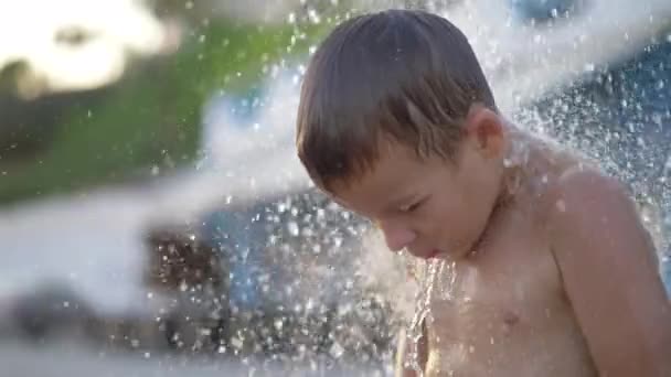 Child taking outdoor beach shower after bathing in sea — Stock Video