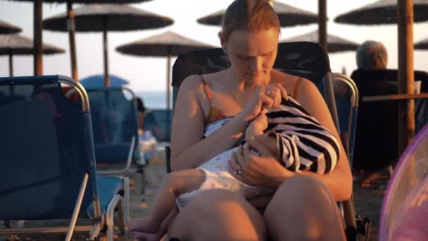 Женщина кормит грудью ребенка на пляже — стоковое видео