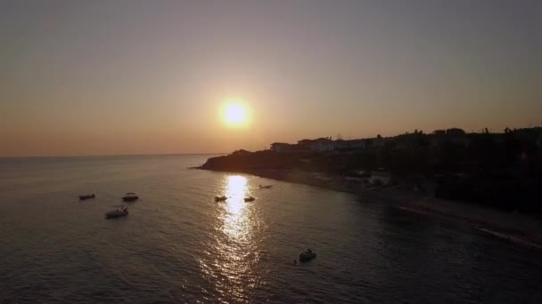 Zonsondergang scène van het resort en de zee met boten, luchtfoto. Trikorfo Beach in Griekenland — Stockvideo