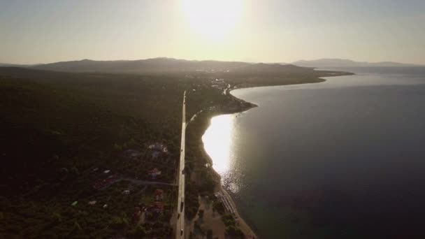 Flygande över havet och kusten med vägen längs vattnet. Trikorfo Beach, Grekland — Stockvideo