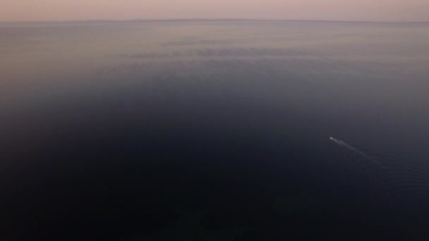Огромное море с парусной моторной лодкой вдалеке — стоковое видео