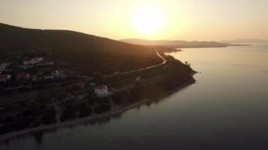 Deniz ve gün batımında, Yunanistan Trikorfo plaj sahil şeridi üzerinde uçan