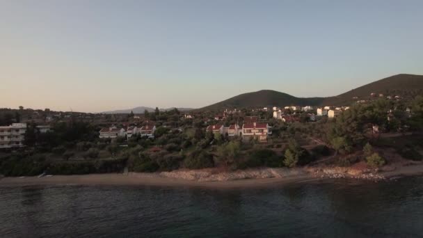 Повітряні сцені пляжу Трікорфо берега з котеджів і зеленими пагорбами, Греція — стокове відео