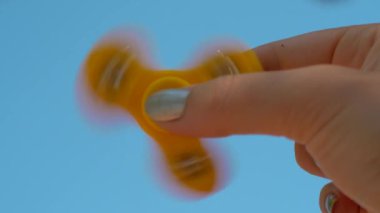Gökyüzü arka plan üzerinde sarı topluca spinner ile oynarken