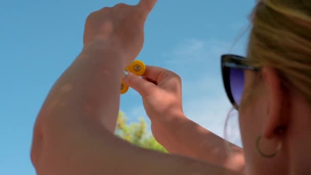 Mujer jugando con amarillo fidget spinner al aire libre — Vídeo de stock