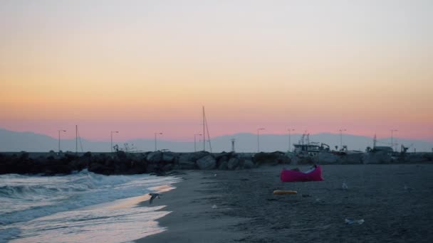 Ο άνθρωπος χαλαρώνοντας στην παραλία και το βράδυ σκηνή της θαλάσσης με τους γλάρους — Αρχείο Βίντεο