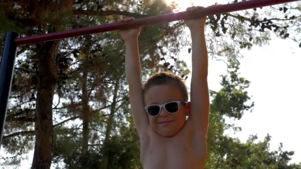 Dítě na pull-up bar sportovní pozemní venkovní — Stock video