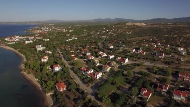 Vista aérea de terras verdes e casas na costa do mar. Trikorfo Beach, Grécia — Vídeo de Stock