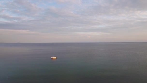 Voando sobre mar tranquilo com um único barco — Vídeo de Stock
