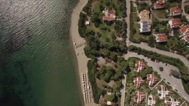 Aerial shot of resort town with cottages on sea coast, Greece — Stock Video