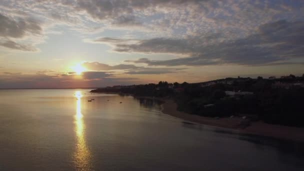 Costa com casas e pôr do sol dourado sobre o mar, aéreo. Trikorfo Beach, Grécia — Vídeo de Stock