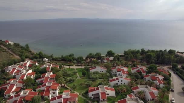 Курортная зона с коттеджами на берегу огромного синего моря, воздушная — стоковое видео