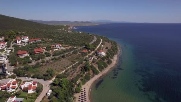 Fliegen über Meer, Ferienhäuser und Resort an der Küste. Strand von Trikorfo, Griechenland — Stockvideo