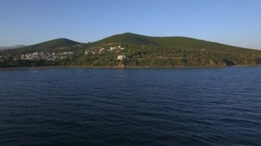 Rıhtımlar üzerinde Yunanistan sahil evleri ile denizden uçan uçak