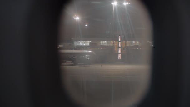 View to night Sheremetyevo Airport from illuminator of arrived plane, Moscow — Stock Video