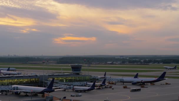 Flygplatsutsikt med flygplan som går ombord och lyfter — Stockvideo