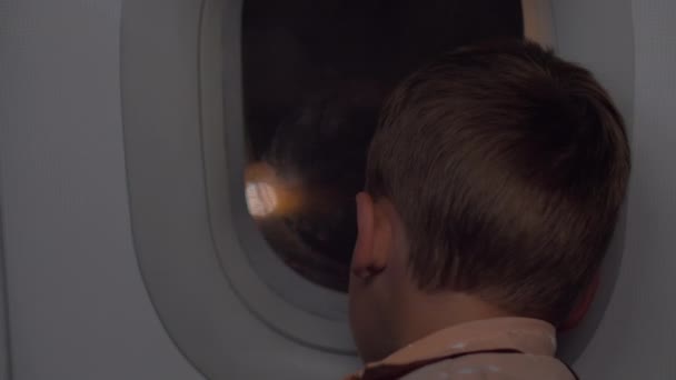 Kind im Flugzeug bei Ankunft am Flughafen in der Nacht — Stockvideo