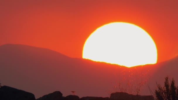Cena do céu vermelho com sol escondido atrás das montanhas — Vídeo de Stock