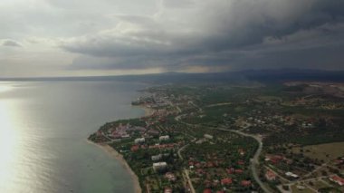 Uçan kıyısında kasabada. Bulutlu gökyüzü, Yunanistan ile göster