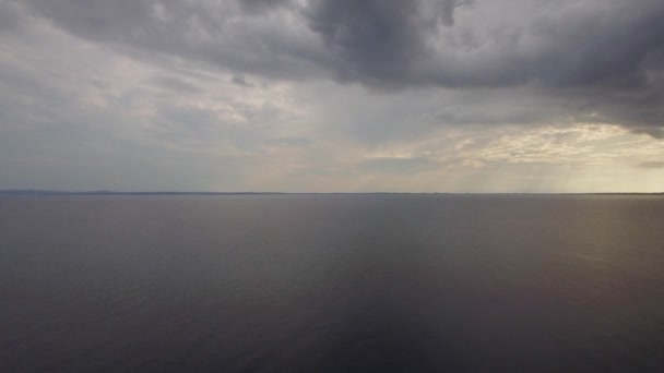Вид с воздуха на тихое море, серые облака в вечернем небе — стоковое видео