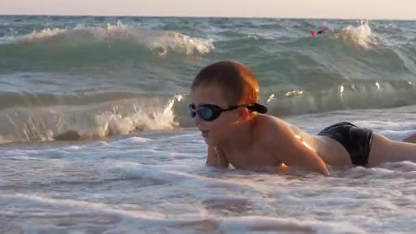 Kind is enthousiast met golven van de zee die betrekking hebben op hem — Stockvideo