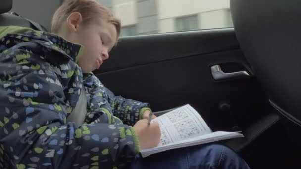 Niño resolver rompecabezas de ajedrez en el coche — Vídeos de Stock