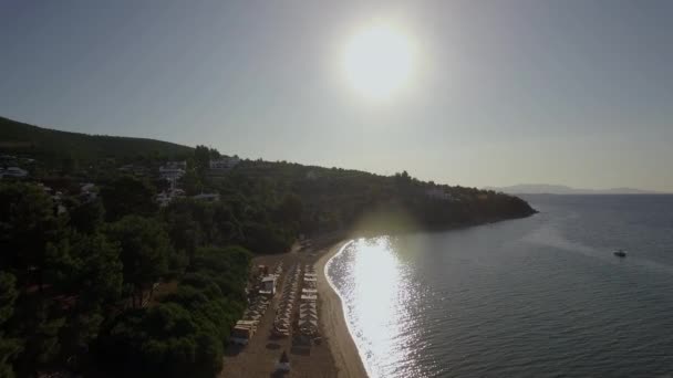 明るい太陽の光、ギリシャの海岸にリゾートがあり、サンベッドの航空写真 — ストック動画