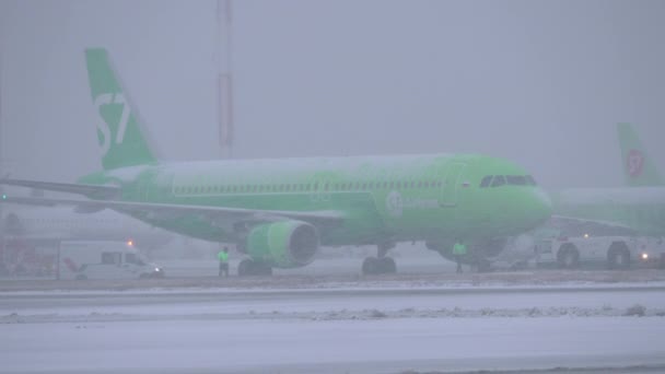 S7 vliegtuig wordt getrokken door vliegtuigen sleepboot op Moskou Luchthaven Domodedovo — Stockvideo