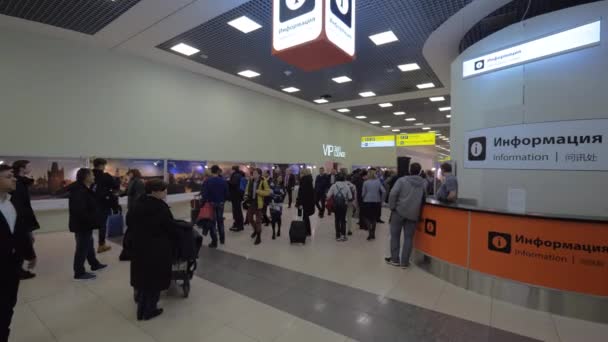 Gente en el vestíbulo del aeropuerto de Sheremetyevo con exposición de fotos de Praga, Moscú — Vídeos de Stock