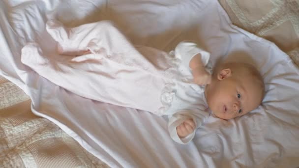 Active réveillé bébé fille de deux mois sur le lit — Video