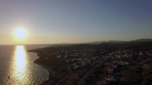Воздушная сцена заката моря и побережья с домами в Трикорфо Бич, Греция — стоковое видео