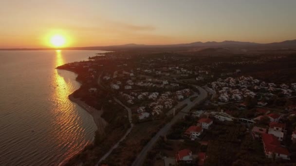 ギリシャの海岸線にコテージ付きの沿岸リゾートタウンの空中ビュー — ストック動画