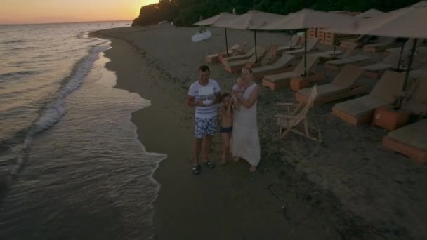 Famiglia in spiaggia e scena aerea della città costiera. Spiaggia di Trikorfo, Grecia — Video Stock