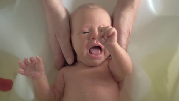 Newborn baby is scared with bathing — Stock Video