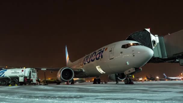 Timelapse de embarque FlyDubai avión y carga de equipaje en la noche de invierno — Vídeo de stock