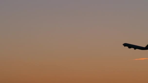 Черный силуэт самолета, летящего в вечернем небе — стоковое видео