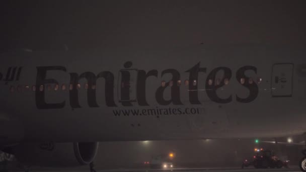 Pushbacking емірату авіалайнера в зимову ніч. Аеропорт Домодєдово, Москва — стокове відео