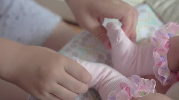 Boy playing with baby sister and rocking her in the chair — Stock Video