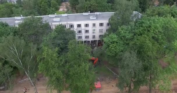 Vzdušný pohled na polozbořenou budovu mezi zelenými stromy — Stock video