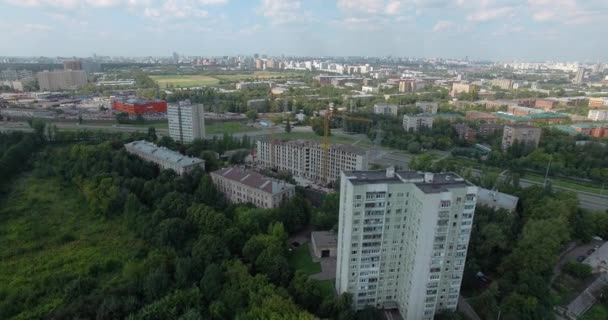 An aerial view of a sunny urbanscape among green trees — 비디오