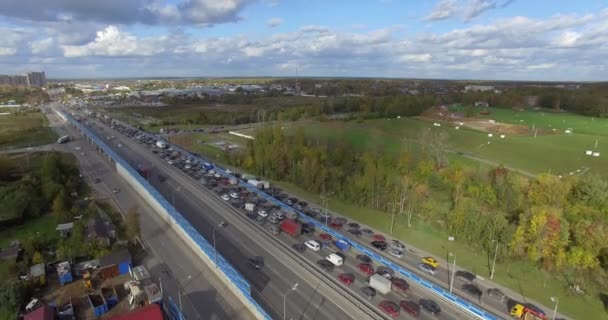 Una carretera concurrida con un atasco de tráfico junto con el paisaje verde — Vídeo de stock