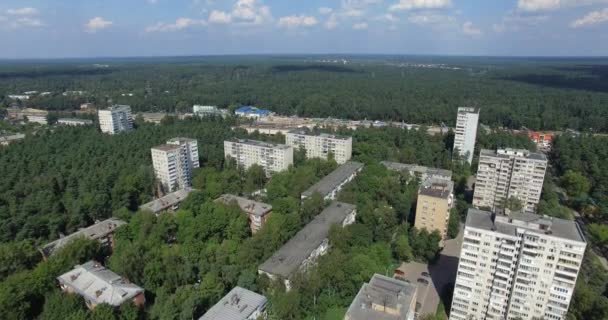 Uma vista aérea de edifícios residenciais de vários andares afogando-se em coroas de árvores verdes — Vídeo de Stock